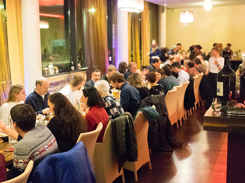 Ein Bild von der entegra- Weihnachtsfeier mit den Mitarbeitenden an einer langen Tafel.